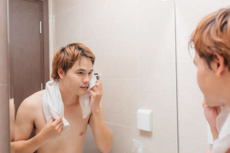 Attractive man drying his face in the mirrorの写真素材