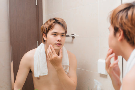 morning routine: a man looking at himself at the mirrorの写真素材