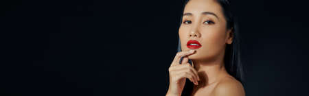 Closeup of beautiful smiling woman touching soft smooth facial skinの写真素材