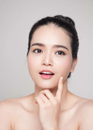 Happy smiling beautiful asian woman touching her face.の写真素材