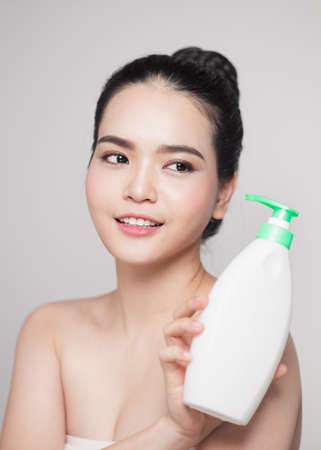 Shower gel. Joyful young woman advertising care product.の写真素材