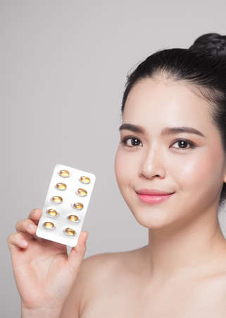 Healthy happy asian woman with pills in hand.の写真素材
