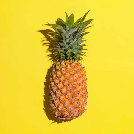 Summer fruit. Pineapple on bright yellow background.の写真素材