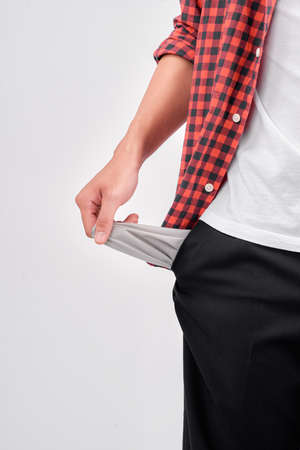 Young broke man is showing his empty pocketsの写真素材