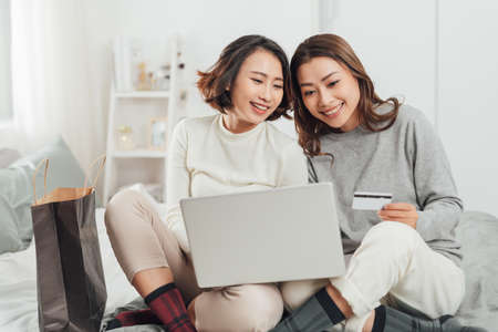 Beautiful female friendship enjoy weekend activity lifestyle with technology at home.の写真素材