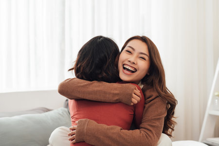 Young woman hugging her friend at home.の写真素材