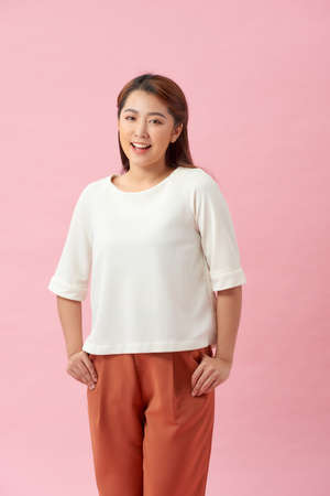 Portrait of beautiful asian woman smiling against pink wallの写真素材