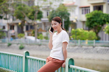 Portrait of a beautiful young woman standing outside using mobile phoneの写真素材