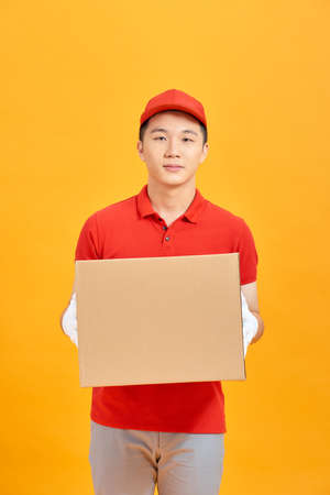 Portrait of a male delivery man holding a cargo box, backgroundの写真素材