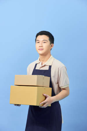 Asian smart handsome male holding boxes for delivery to customersの写真素材