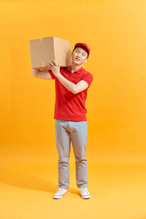 Mail man deliver package, shipping order from post man with red uniformの写真素材