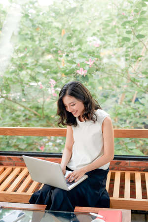 Full length portrait of cheerful charming person sit hold netbook browsing have good mood working home indoorsの写真素材