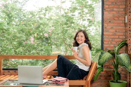 cheerful charming person sit hold netbook browsing have good mood working home indoorsの写真素材