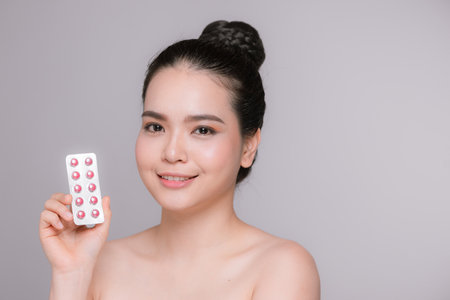 Girl is holding pack of pill with vitaminsの写真素材