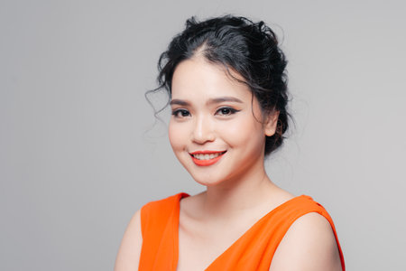 Beautiful asian âgirl with red lips with bright makeup on a faceの写真素材