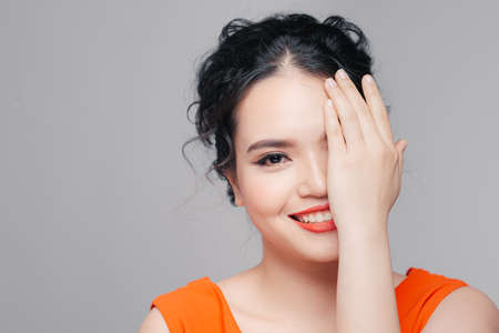 Pretty stylish woman hiding half of face behind handの写真素材
