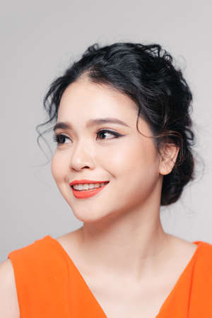 Beautiful asian âgirl with red lips with bright makeup on a faceの写真素材
