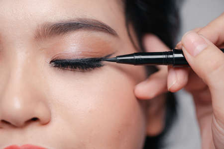 young woman applied eyeliner close-upの写真素材