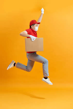 Male employee in cap t-shirt print working as courier dealer hold empty cardboard boxの写真素材
