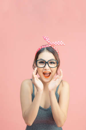 Beautiful girl with pretty smile in pin up style on pink backgroundの写真素材