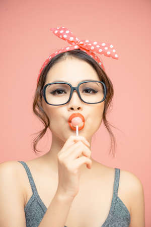Pin Up styling girl eating lollipopの写真素材