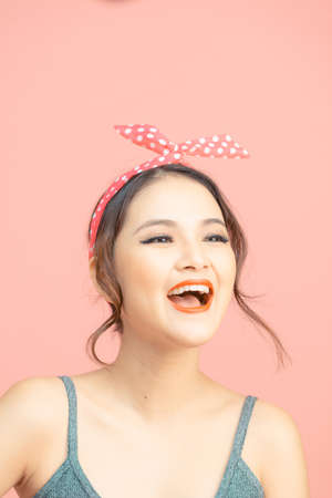 Portrait of beautiful young woman with bun hair on pink backgroundの写真素材