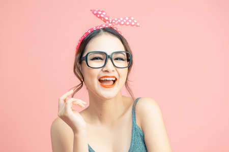 Fashionably dressed girls posing on a pink backgroundの写真素材