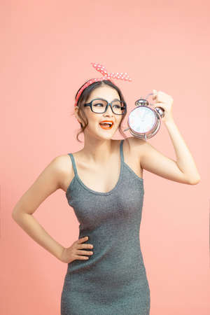Amazed pin-up woman holding clock.の写真素材