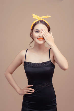 Young cute woman isolated on pink background covers eye with hand.の写真素材