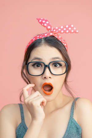 Portrait of lovely amazed cheerful girl sudden good news reaction delight isolated over pink pastel color backgroundの写真素材