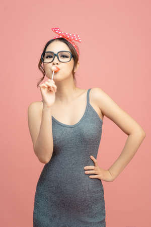 Glamor beautiful young woman model with red lips eat sweets lollipopの写真素材