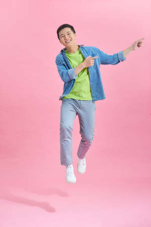 Happy jumping man pointing somethingの写真素材