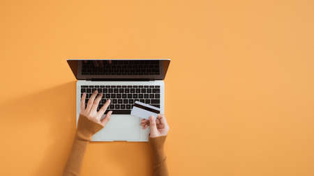 Hands holding credit card, typing on the keyboard of laptop, onine shoppingの写真素材
