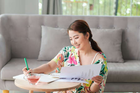 Portrait of an attractive young student doing her homework at homの写真素材