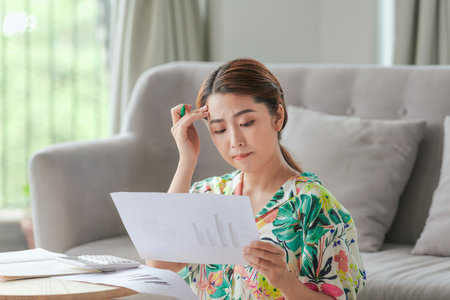Attractive asian woman doing homework at homeの写真素材