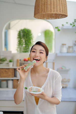 woman eating healthy spring rollの写真素材
