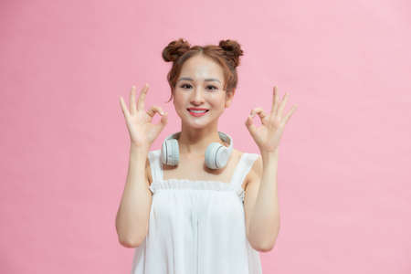 Attractive young adult woman showing ok signの写真素材
