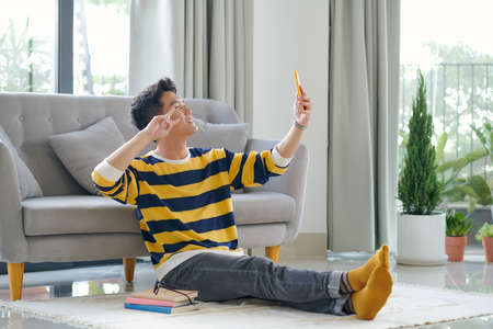 The guy takes a selfie, speaks via videoの写真素材