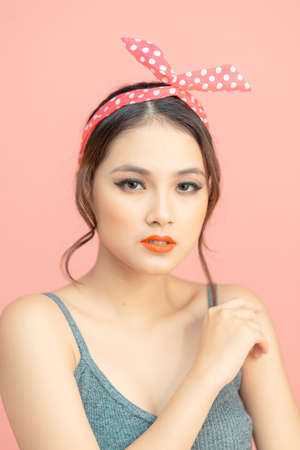 Beautiful thinking girl posing on pink backgroundの写真素材