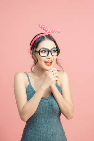 Lovable girl good news reaction isolated over pink backgroundの写真素材
