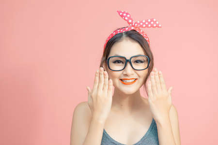 Pretty lady hold palm hands near cheeks isolated on pink backgroundの写真素材
