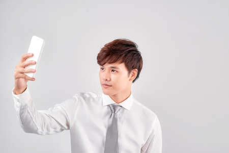 asian man take selfie over white backgroundの写真素材