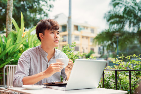 young man using a laptop for work outdoorの写真素材