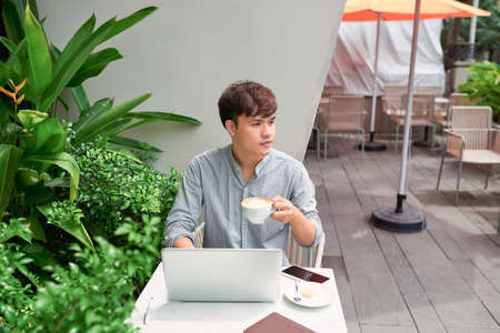 Young asian economist using laptop in coffee shopの写真素材