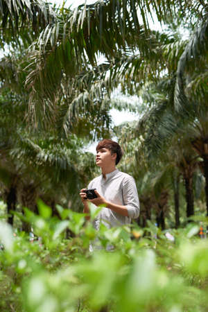 man holding digital camera outdoorの写真素材