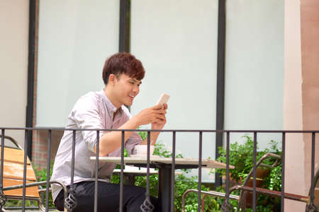 Young man is using a notebook computer in the gardenの写真素材