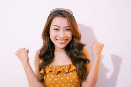Young woman celebrating surprised and amazed for success with arms raised and open eyesの写真素材