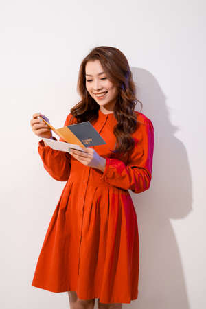 Young happy beautiful woman is reading postcard.の写真素材