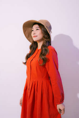 Portrait of an Asian woman wearing a wide-brimmed hat and summer clothes isolated on pink backgroundの写真素材