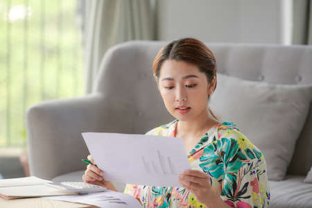 Woman with papers in their living roomの写真素材